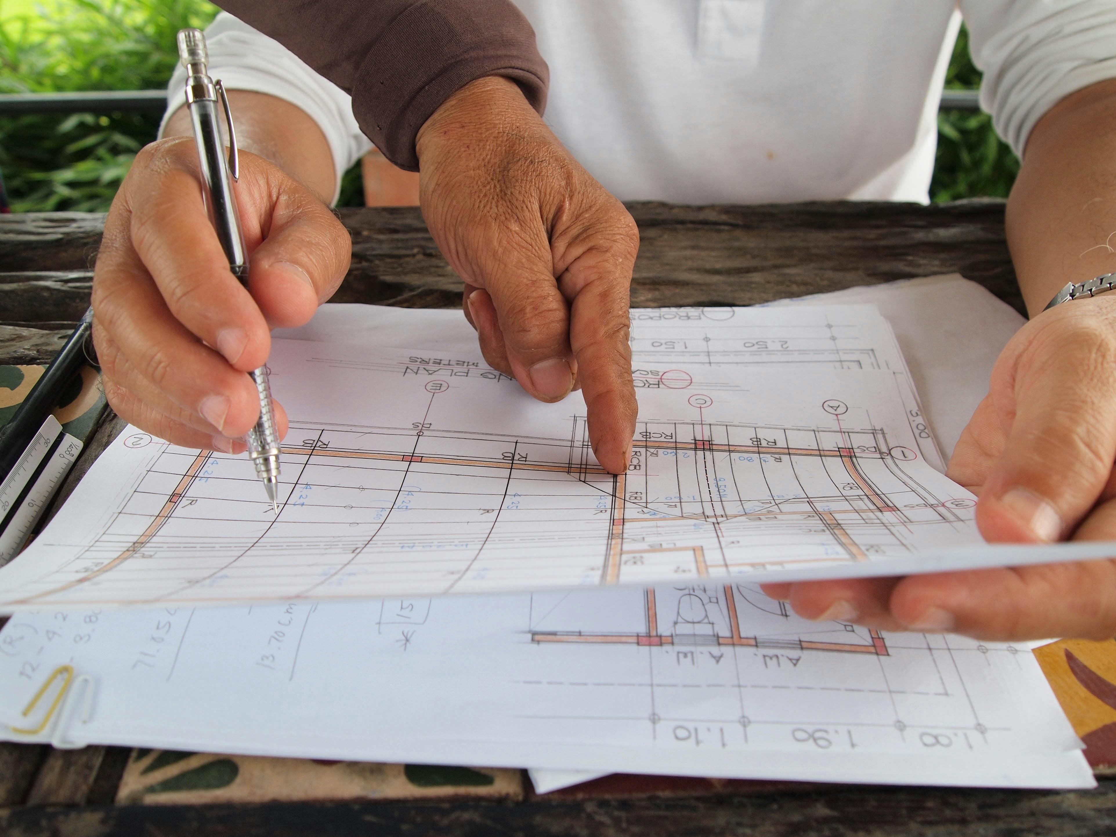 Hands reviewing construction plans